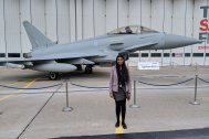 Photo of Krystina stood outside in front of a grey and black aircraft.