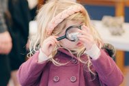 Child examining a rock sample through a magnifying glass
