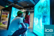 An adult and child looking at an exhibition panel which is casting a blue light